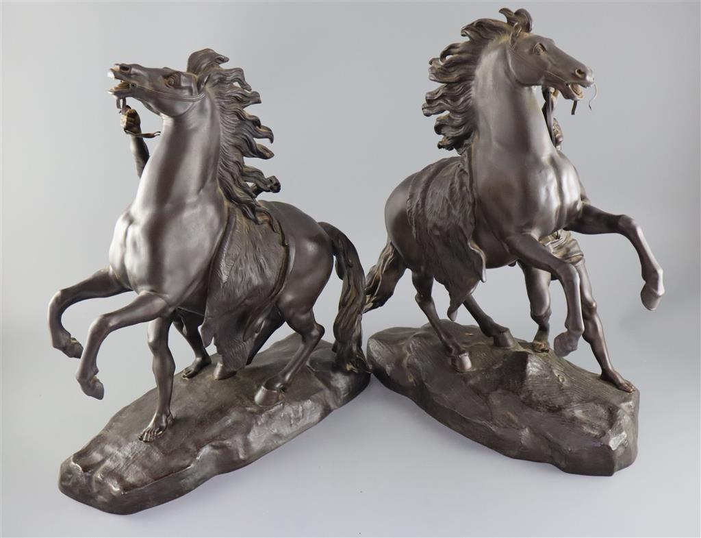 After Guillaume Coustou the Elder (French 1677-1746). A pair of bronze Chevaux de Marly, height 19in.